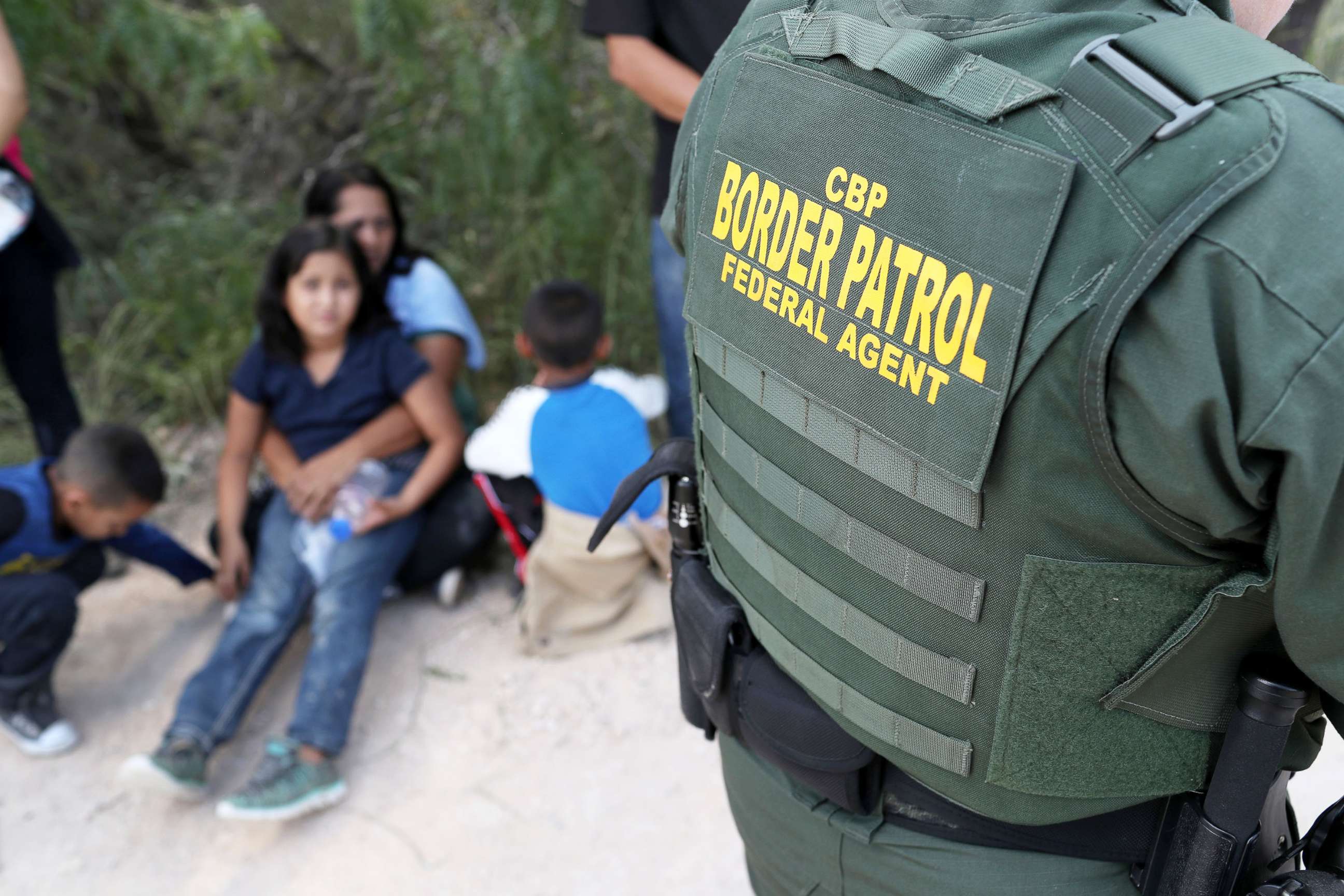 PHOTO: Central American asylum seekers wait as U.S. Border Patrol agents take them into custody on June 12, 2018 near McAllen, Texas.