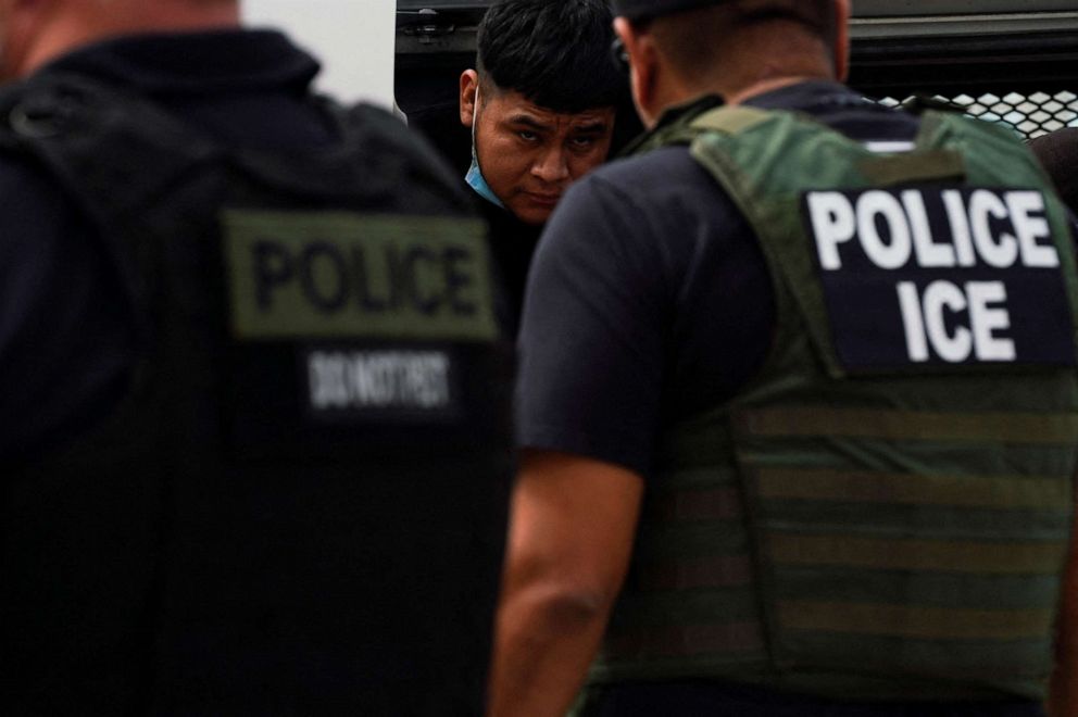 FILE PHOTO: A migrant who was previously detained gets off a van coming from Waco while U.S. ICE agents wait for everyone to get down so that their handcuffs can be removed to then be escorted to Mexico, in Laredo, Texas, U.S. June 15, 2022. 