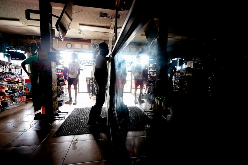 PHOTO: Customers shop in the dark at a convenience store after the effects the effects of Hurricane Ida knocked out power in the area, Aug. 30, 2021, in New Orleans.