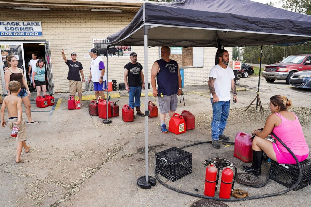 PHOTO: People wait in line to have their gas cans filled, Sept. 1, 2021, in Maurepas, La. 