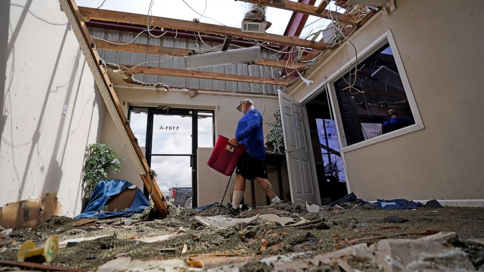 PHOTO: Rene Hebert cleans out the family's destroyed offices as cleans up in the aftermath of Hurricane Ida, Aug. 30, 2021, in Houma, La.