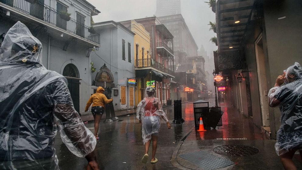 PHOTO: A group of people walk through the French District during Hurricane Ida, Aug.  29, 2021 in New Orleans.