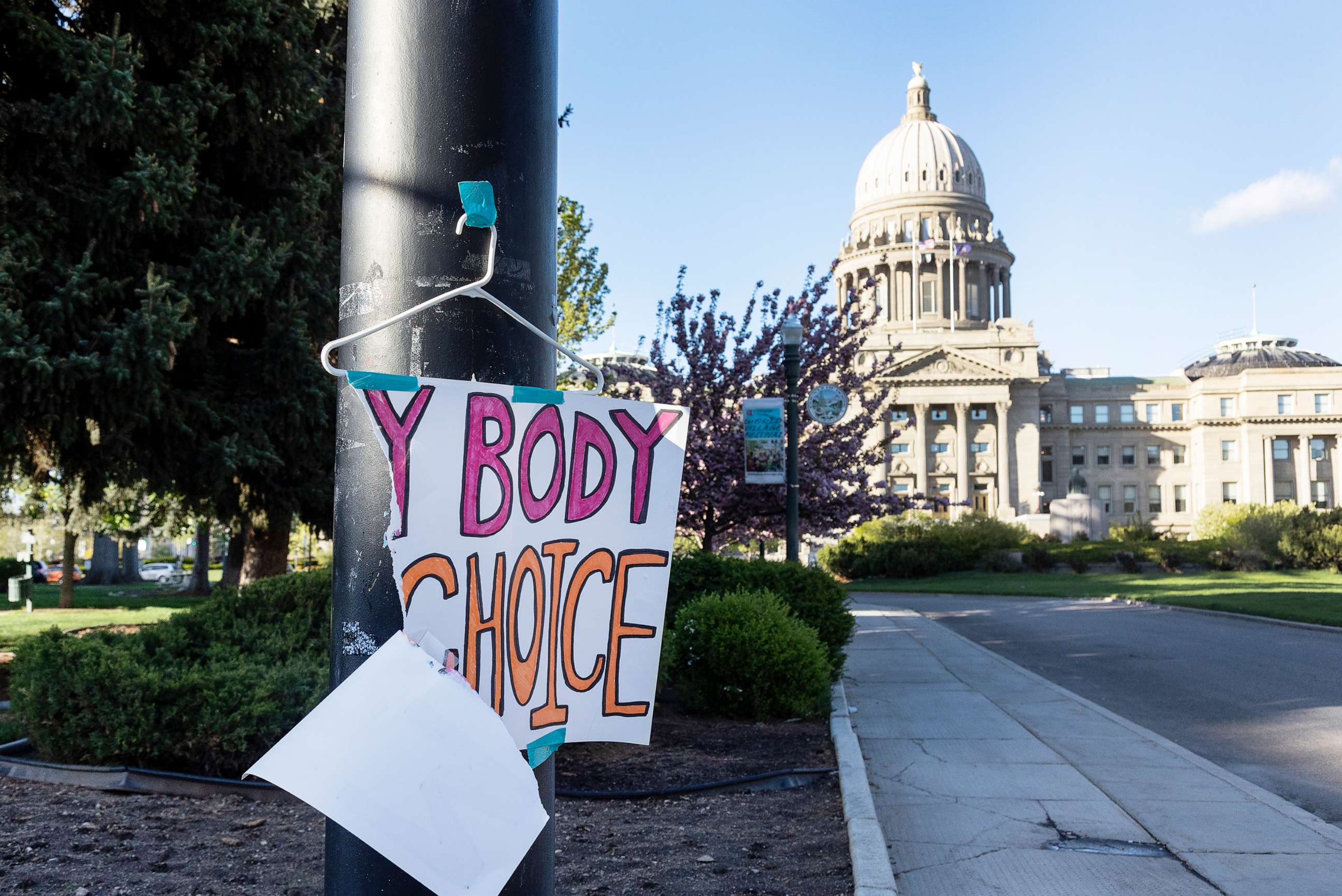 PHOTO: A torn sign reading "My body my choice" on a hanger hangs on a streetlight in front of the Idaho State Capitol Building, May 3, 2022.