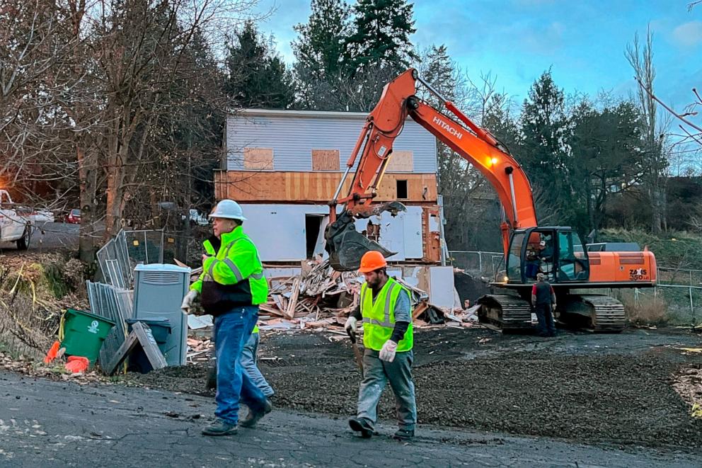 PHOTO: Workers walk past the demolition of a home on Thursday, Dec. 28, 2023, in Moscow, Idaho, where four University of Idaho students were killed last year. The owner of the home near the university campus donated it to the university earlier this year.