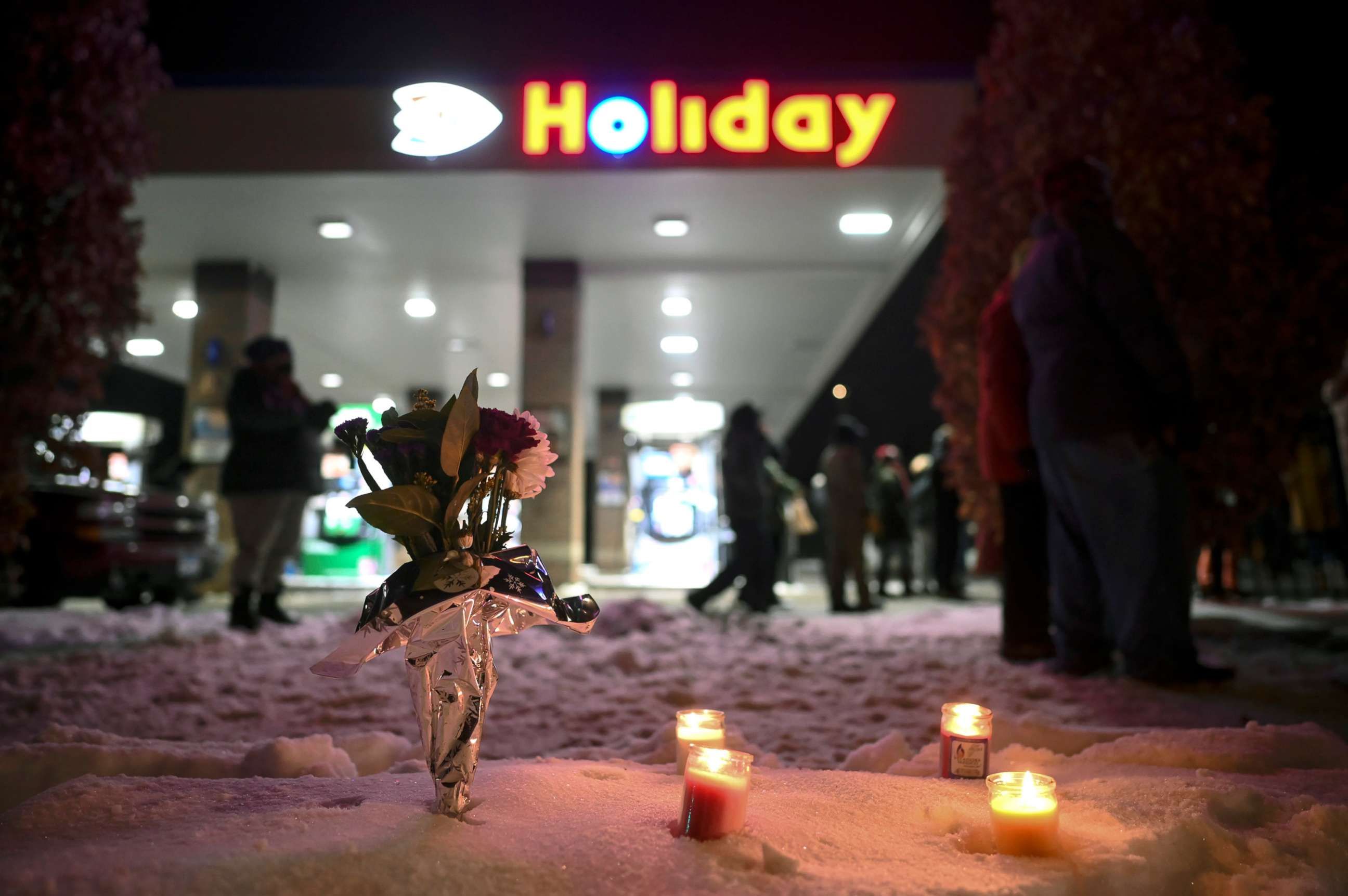 PHOTO: Flowers and candles are left near the Holiday gas station, late Thursday, Dec. 31, 2020, in Minneapolis, where Dolal Idd, 23, was shot and killed by Minneapolis police the night before during a traffic stop.