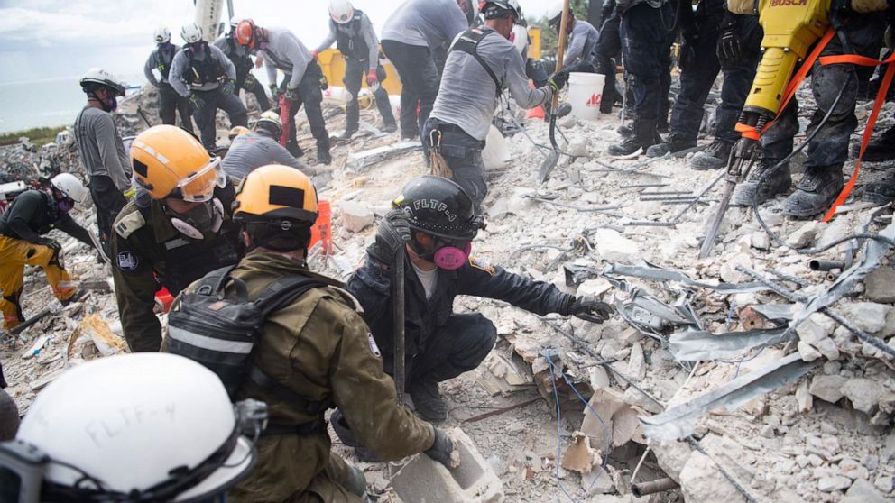PHOTO: Israeli Defense Forces (IDF) search and rescue team members work in the rubble of Champlain Towers South, in Surfside, Fla., near Miami Beach.