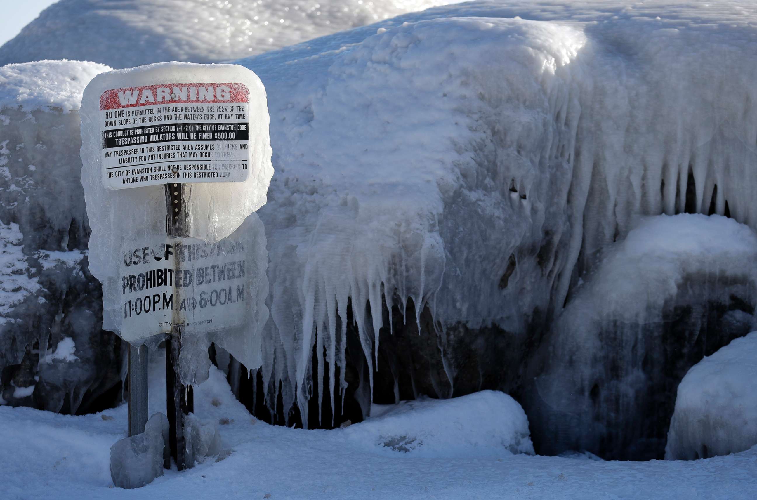PHOTO: A warning sign is covered by ice at Clark Square park in Evanston, Ill., Jan. 30, 2019.