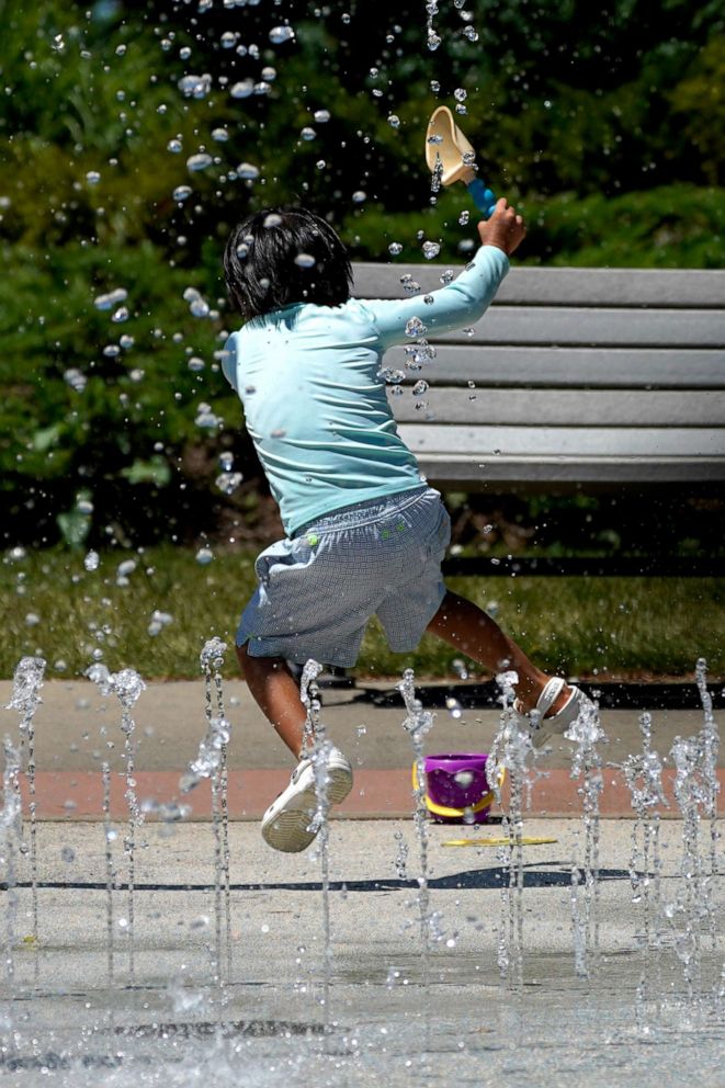 PHOTO: A child cools off during hot weather as he plays with the water fountains at Little Bear Park in Glenview, Ill., July 20, 2022. 