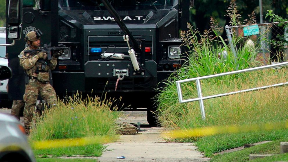 PHOTO: A police officer in tactical gear stands positioned near an Illinois State Police SWAT vehicle outside a building on 42nd Street near Van Buren Avenue, on Friday, Aug 23, 2019, in East St. Louis, Ill., after a trooper was shot serving a warrant.