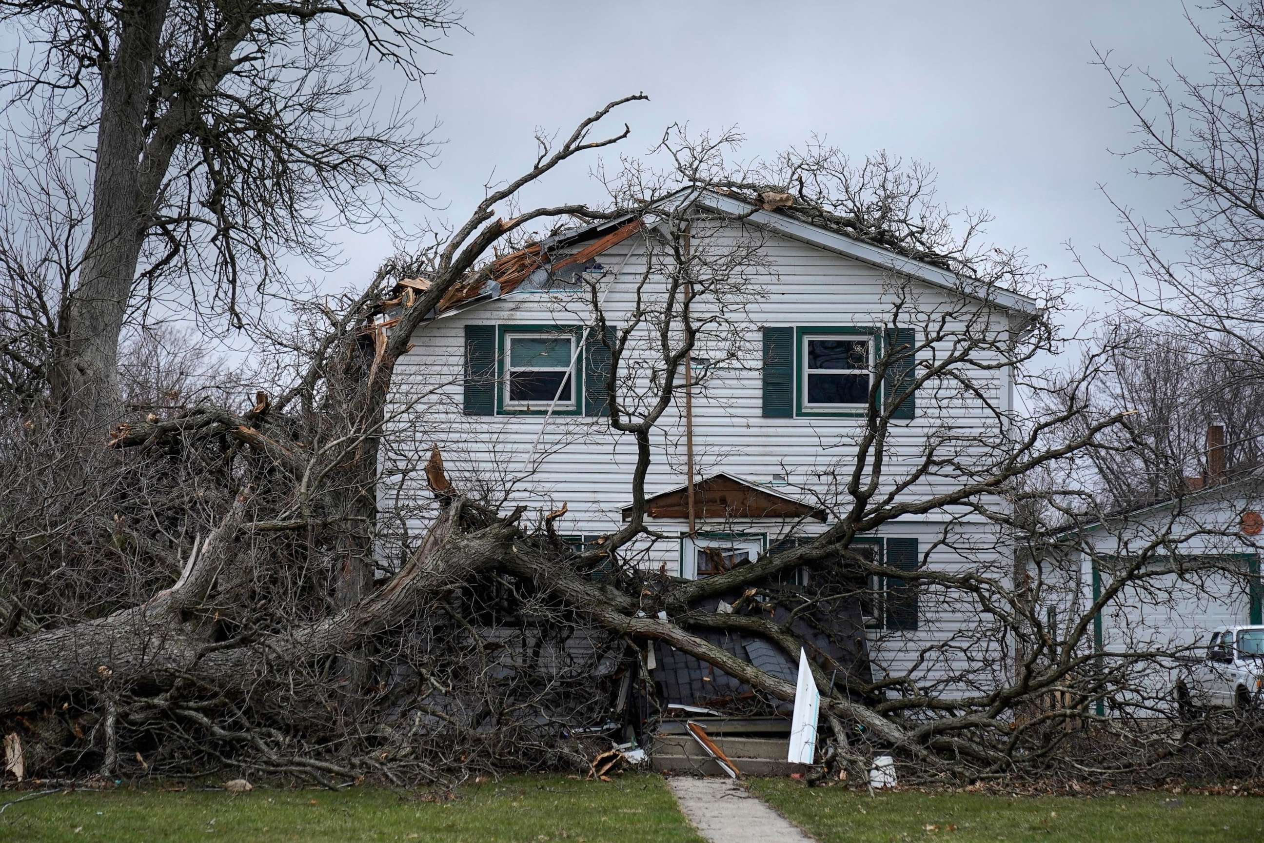 PHOTO: A house is damaged by fallen trees on West Hurlbut Avenue near where the roof of the Apollo Theatre collapsed during a tornado, on April 1, 2023, in Belvidere, Ill.