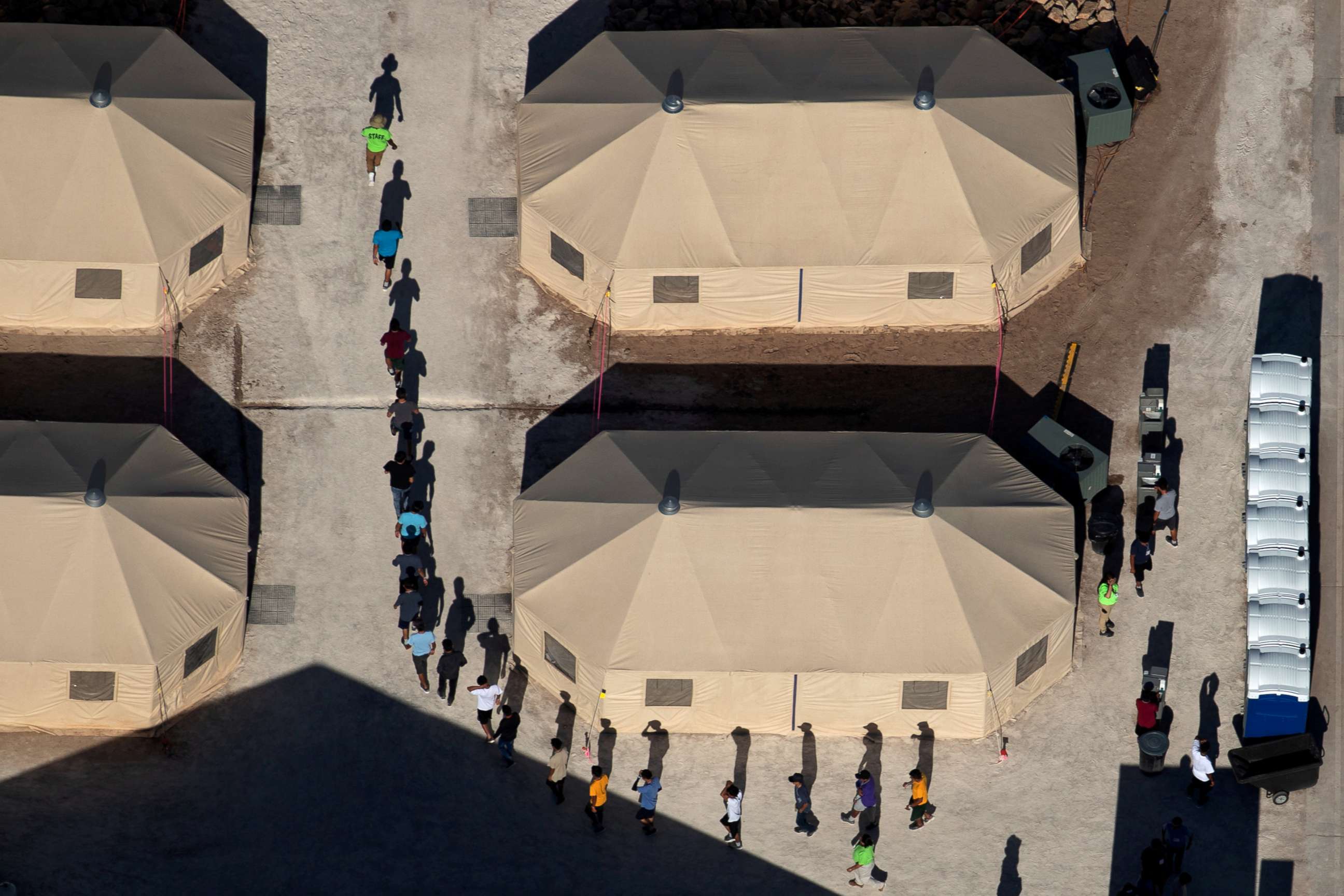PHOTO: Immigrant children are led by staff in single file between tents at a detention facility next to the Mexican border in Tornillo, Texas, June 18, 2018.