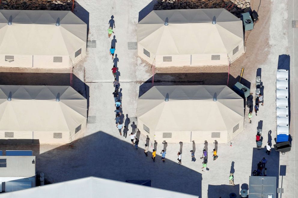 PHOTO: Immigrant children are shown walking in single file between tents in their compound next to the Mexican border in Tornillo, Texas, June 18, 2018.