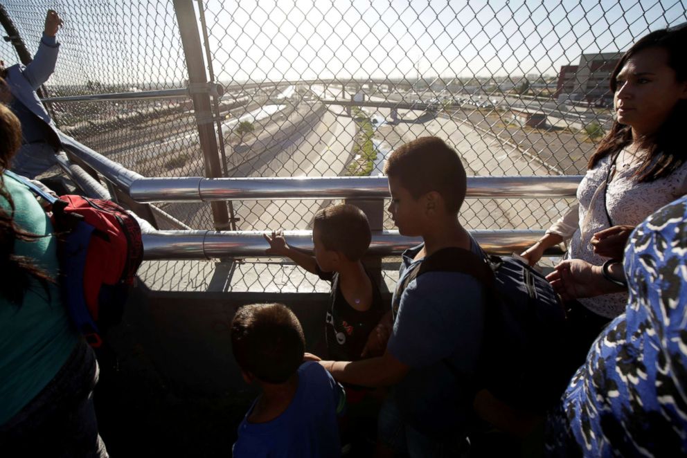 PHOTO: Migrant families from Mexico, fleeing from violence, wait to enter the United States to meet officers of the U.S. Customs and Border Protection to apply for asylum at Paso del Norte international border crossing bridge in Ciudad Juarez.