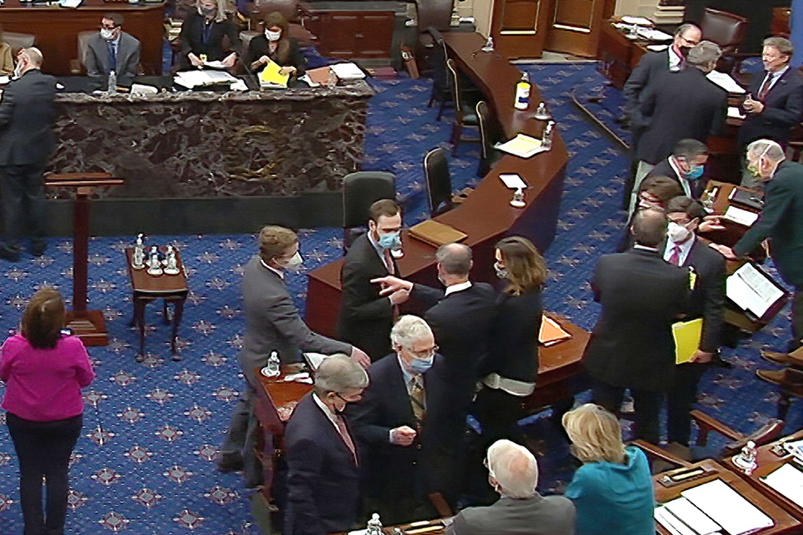 PHOTO: Senate Minority Leader Mitch McConnell and other Republican senators and staff talk on the floor after a vote on the motion to allow witnesses in the second impeachment trial of former President Donald Trump in the Senate. Feb. 13, 2021.