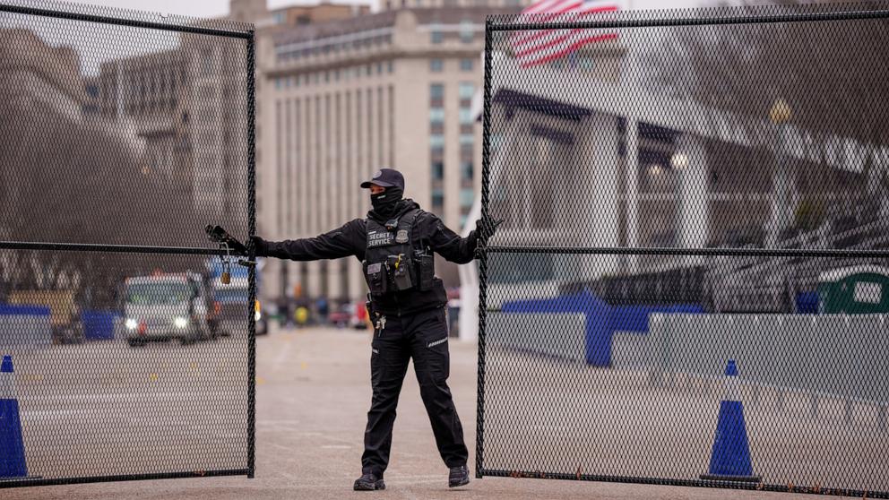 PHOTO: A member of the U.S. Secret Service closes a security gate near the presidential Inauguration parade review stand on Pennsylvania Avenue on the north side of the White House, Jan. 16, 2025, in Washington.