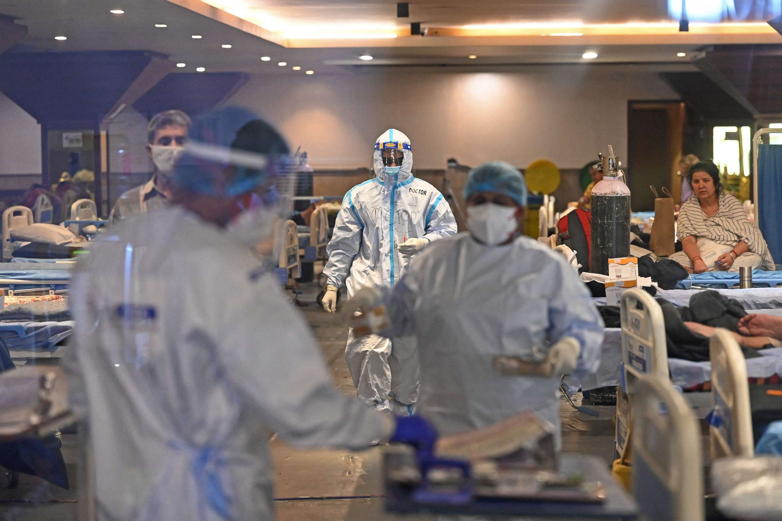 PHOTO: Health workers wearing PPE suits can be seen at a banquet hall turned into a Covid-19 coronavirus care center after surge in cases in New Delhi, May 18, 2021.