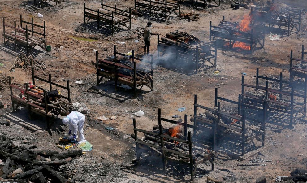 PHOTO: Funeral pyres for COVID-19 victims burn during a mass funeral at a makeshift cremation ground at Giddenahalli in Bangalore, India, May 18, 2021.