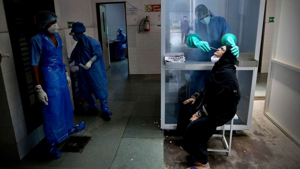 PHOTO: A health worker takes a nasal swab of a woman for COVID-19 test at a hospital in New Delhi, India, July 6, 2020.