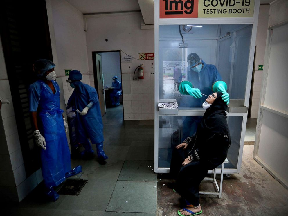 PHOTO: A health worker takes a nasal swab of a woman for COVID-19 test at a hospital in New Delhi, India, July 6, 2020.