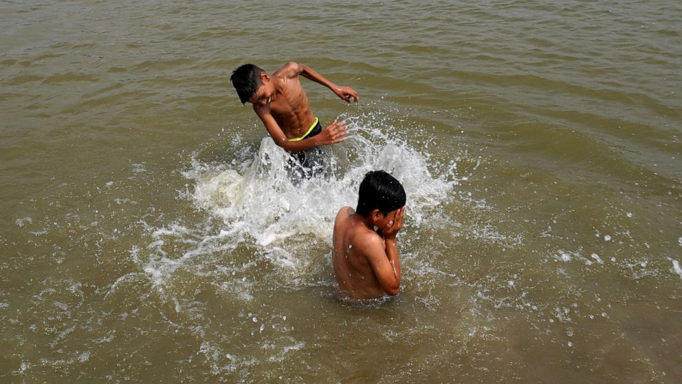 PHOTO: Boys splash water on each other as they swim in a pond on a hot summer day, amid the ongoing heatwave in New Delhi, India, June 27, 2022. 