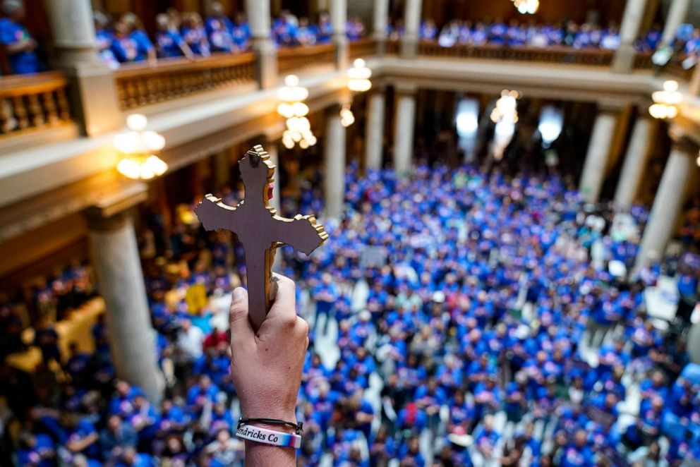 Luke Howard holds a crucifix aloft as anti-abortion supporters rally as the Indiana Senate Rules Committee discusses a Republican proposal to ban nearly all abortions in the state during a hearing at the Statehouse in Indianapolis, July 26, 2022.