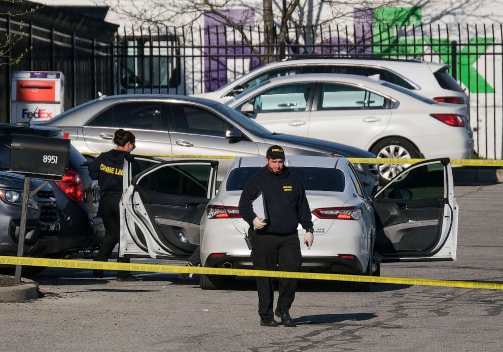 PHOTO: Crime scene investigators walk through the parking lot of the mass shooting site at a FedEx facility in Indianapolis, Indiana, April 16, 2021.