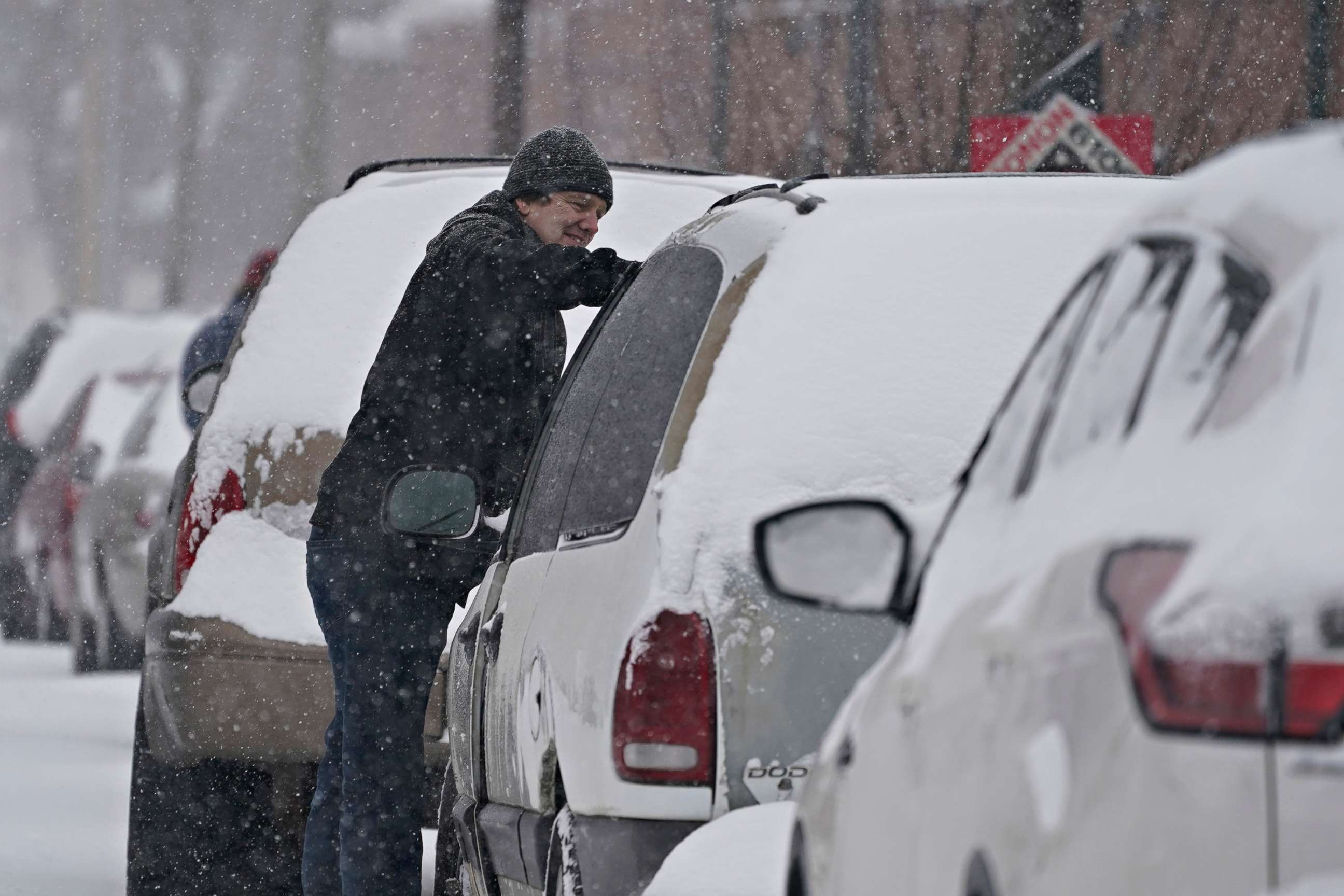 PHOTO: A motorist cleans his vehicle of snow, Feb. 3, 2022, in Indianapolis.