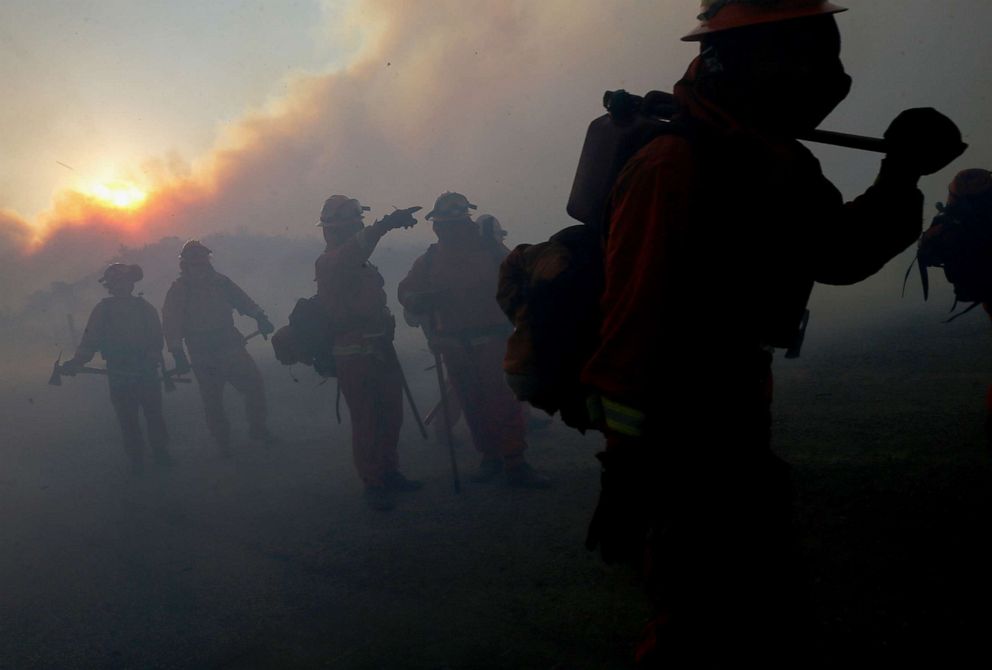 PHOTO: Inmate firefighters work as the Bond Fire burns just after sunrise in the Silverado Canyon area of Orange County on Dec. 3, 2020 near Irvine, Calif.