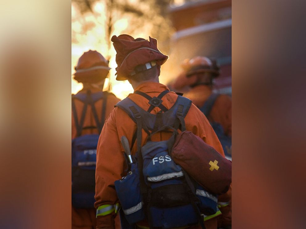 PHOTO: A 2007 file photo of an inmate volunteer firefighter member of the Angels in Orange? marches into a California wildfire wearing the signature orange uniform and carrying heavy gear.