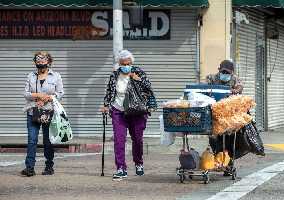 PHOTO: Pedestrians cross the street while walking along Whittier Blvd. in East Los Angeles, April 7, 2021.  