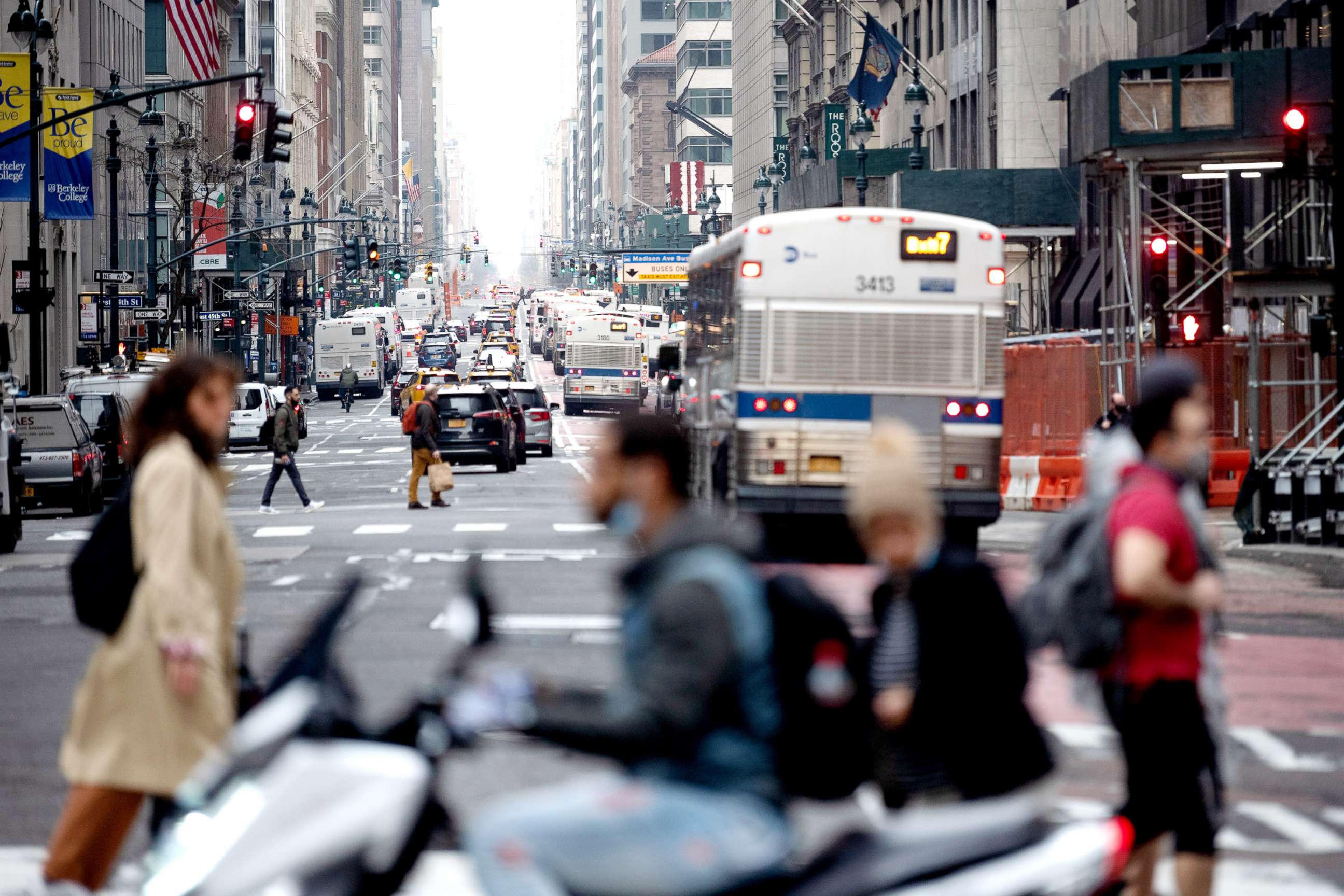 PHOTO: Traffic is seen along Madison Avenue behind pedestrians crossing the road during rush hour on March 25, 2021 in New York City. 