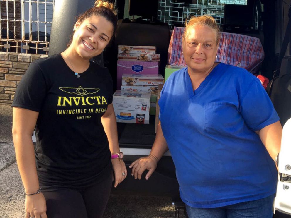 PHOTO: An Invicta Watch Group worker helps deliver aid that was sent from the company's CEO to Maria Ortiz, right, a caregiver at a nursing home in Puerto Rico. 