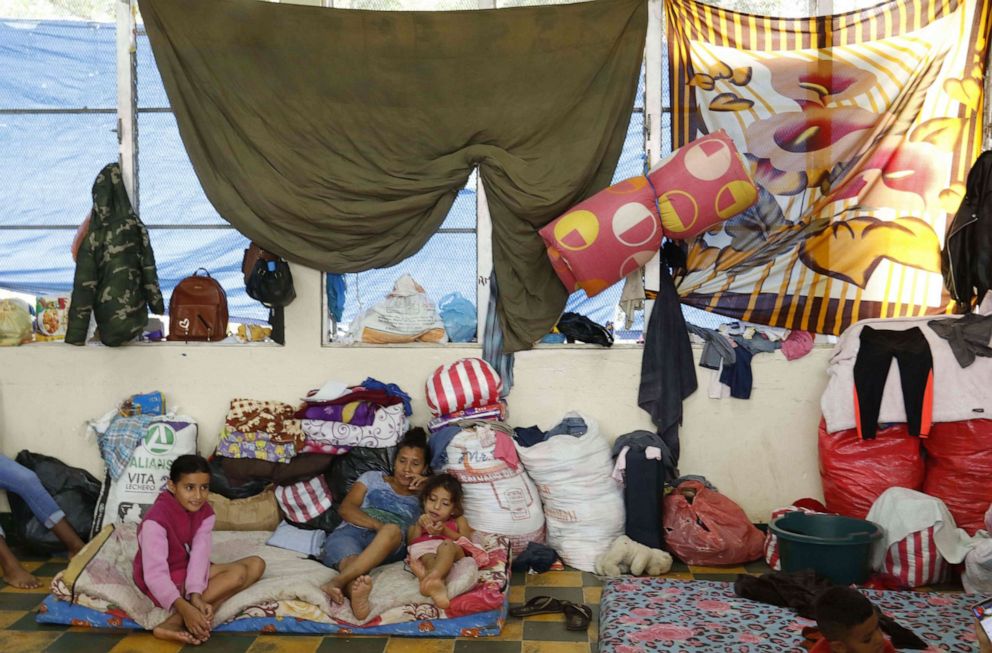 PHOTO: A woman and two children remain at an improvised shelter at the Perla del Ulua Institute in El Progreso, in Honduras, Nov. 18, 2020, after the Ulua River flooded during the passage of Hurricane Iota.