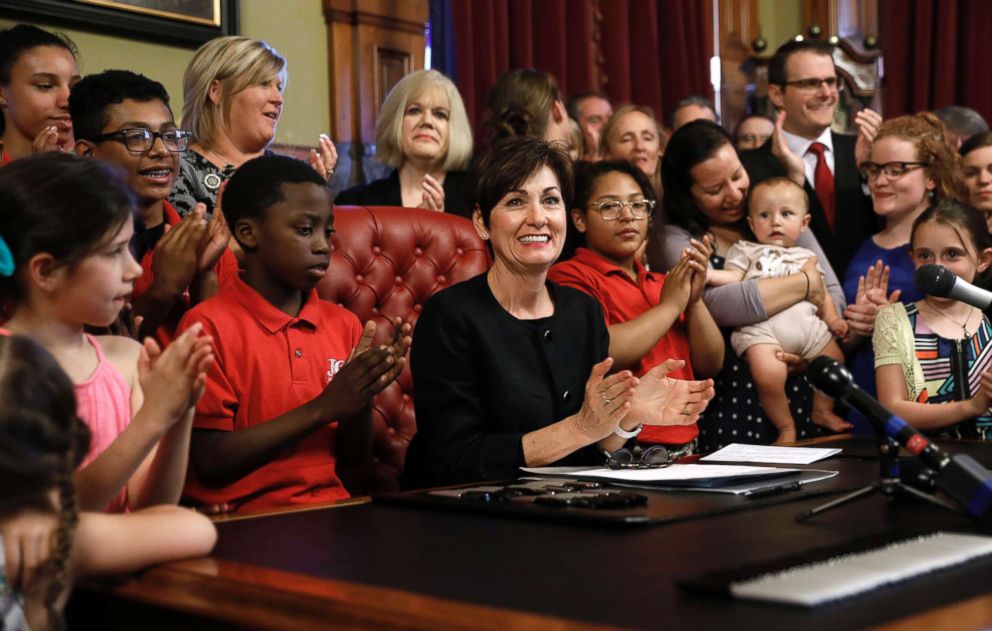 PHOTO: Iowa Gov. Kim Reynolds, center, claps after signing a six-week abortion ban bill into law during a ceremony in her formal office, May 4, 2018, in Des Moines, Iowa.