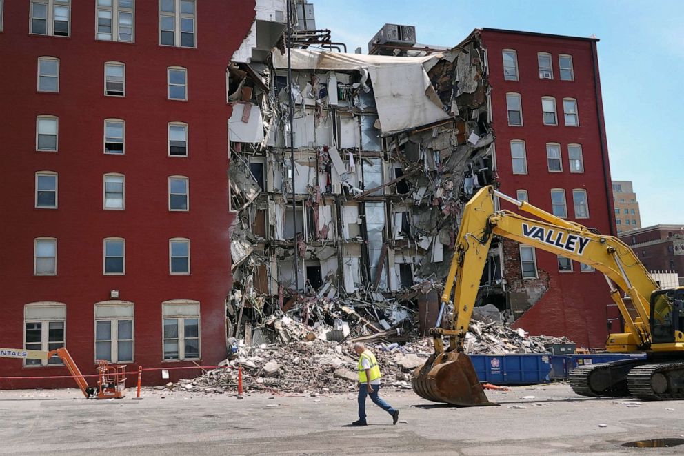 PHOTO: A worker walks by a six-story apartment building after it collapsed on May 28, 2023 in Davenport, Iowa.