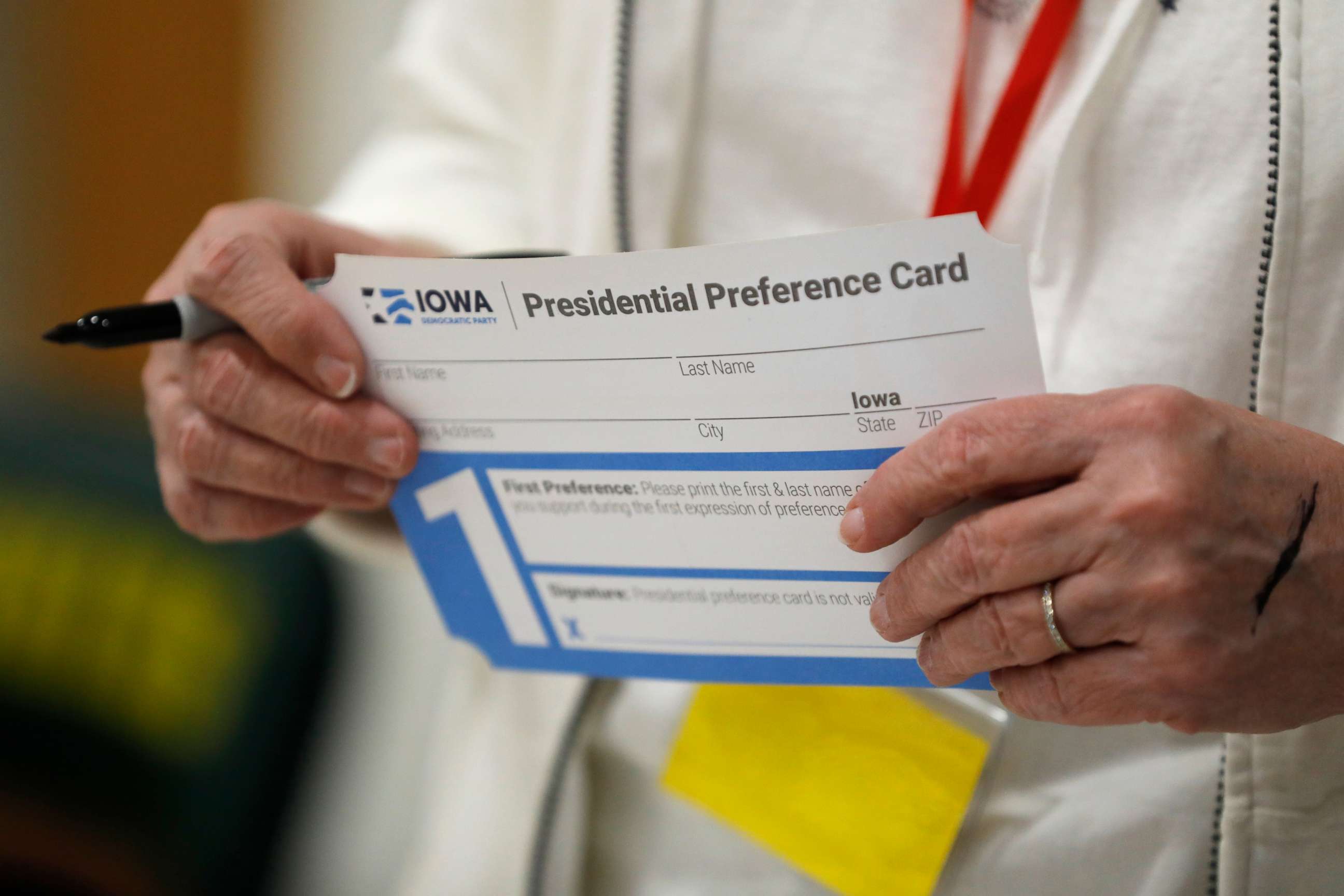 PHOTO: A volunteer holds a Presidential Preference Card before the start of a Democratic caucus at Hoover High School, Feb. 3, 2020, in Des Moines, Iowa.