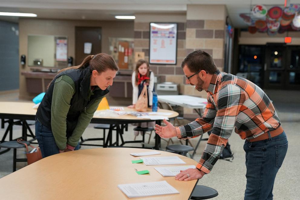 PHOTO: Workers talk as they make preparations at a caucus site in Ames, Iowa, Jan. 15, 2024.