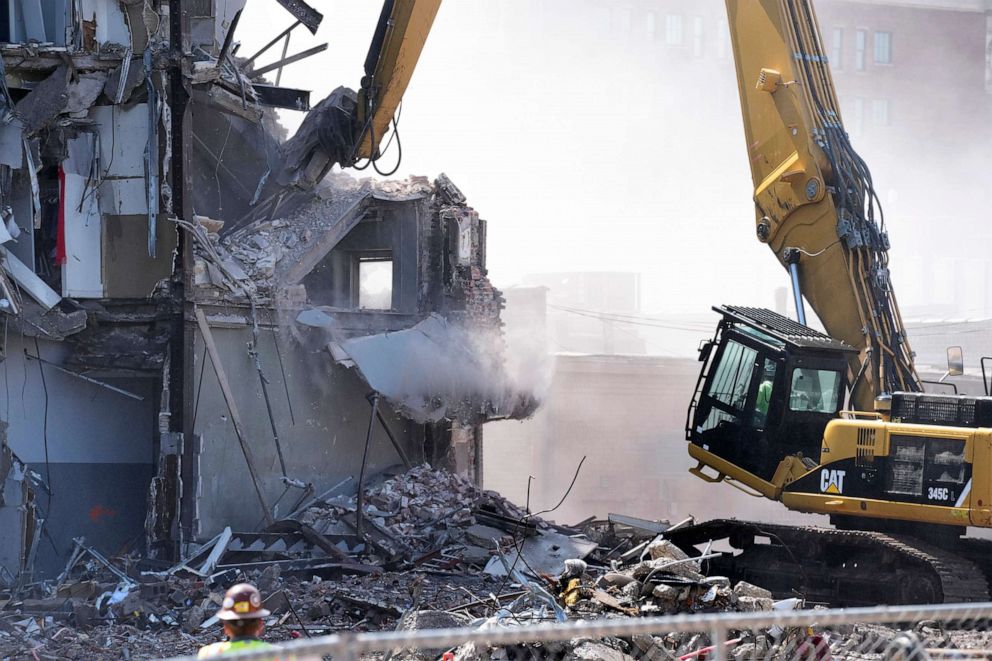 PHOTO: A worker watches debris fall during demolition at the site of a building collapse, June 12, 2023, in Davenport, Iowa.
