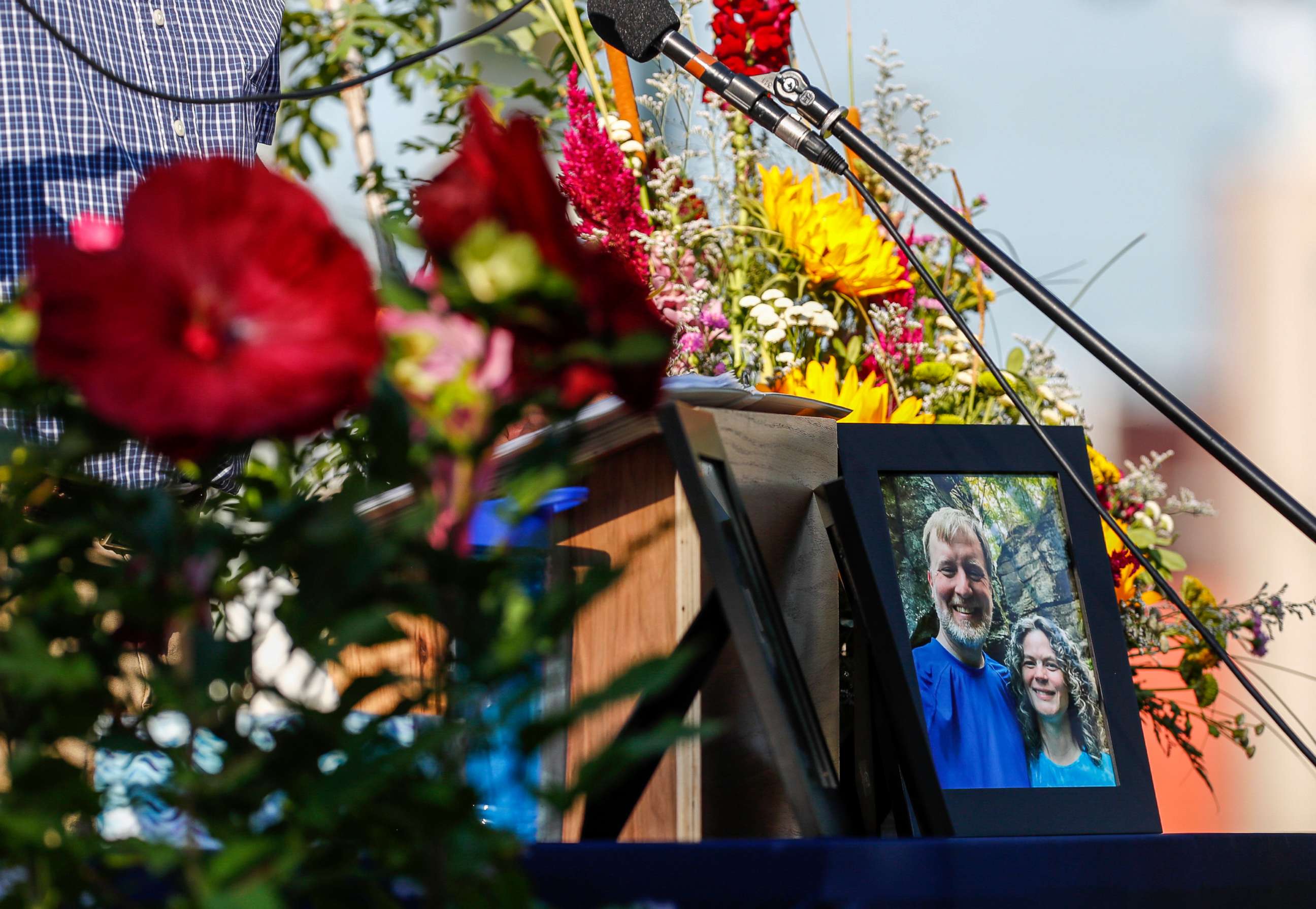 PHOTO: A photo of Tyler and Sarah Schmidt sits on the podium during the Celebration of Life event for Tyler, Sarah, and Lula Schmidt held at Overman Park, Aug. 2 2022 in Cedar Falls, Iowa.
