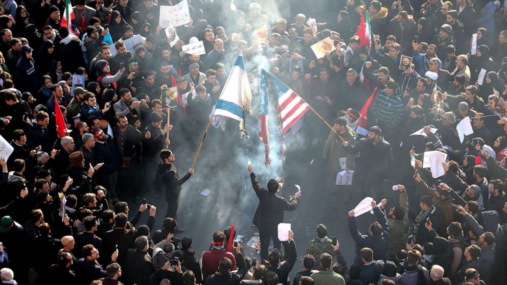 PHOTO: Iranians set a U.S. and an Israeli flag on fire during a funeral procession for Qassem Soleimani and other victims of a U.S. drone strike, in the capital Tehran on Jan. 6, 2020.