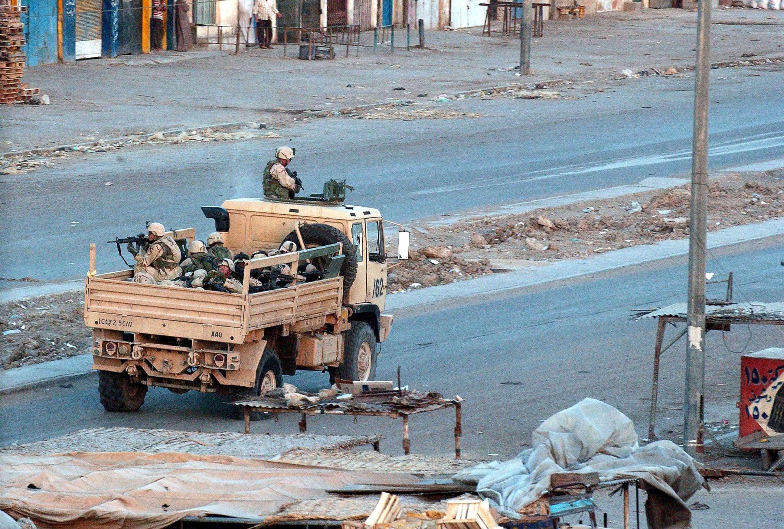 PHOTO: U.S. troops patrol the deserted streets of the sprawling Shia slum of Sadr City at sunset after a day of tense clashes across the country with supporters of controversial Shia cleric Moqtada al-Sadr, April 4, 2004, in Sadr City, Iraq. 