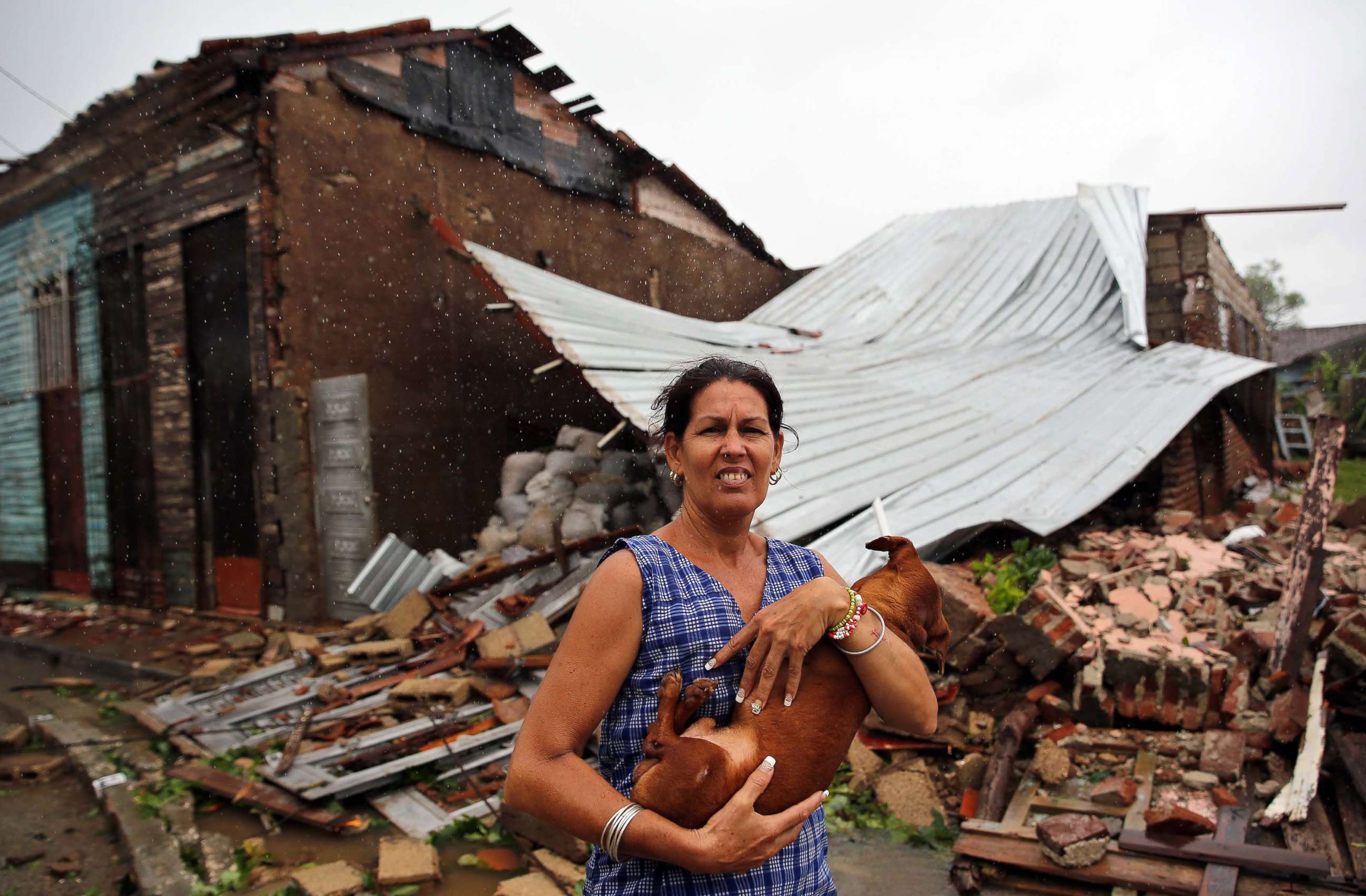 PHOTO: A woman holds her dog in front of her destroyed house after the Hurricane Irma, at the central city of Remedios, Cuba, Sept. 9. 2017. 