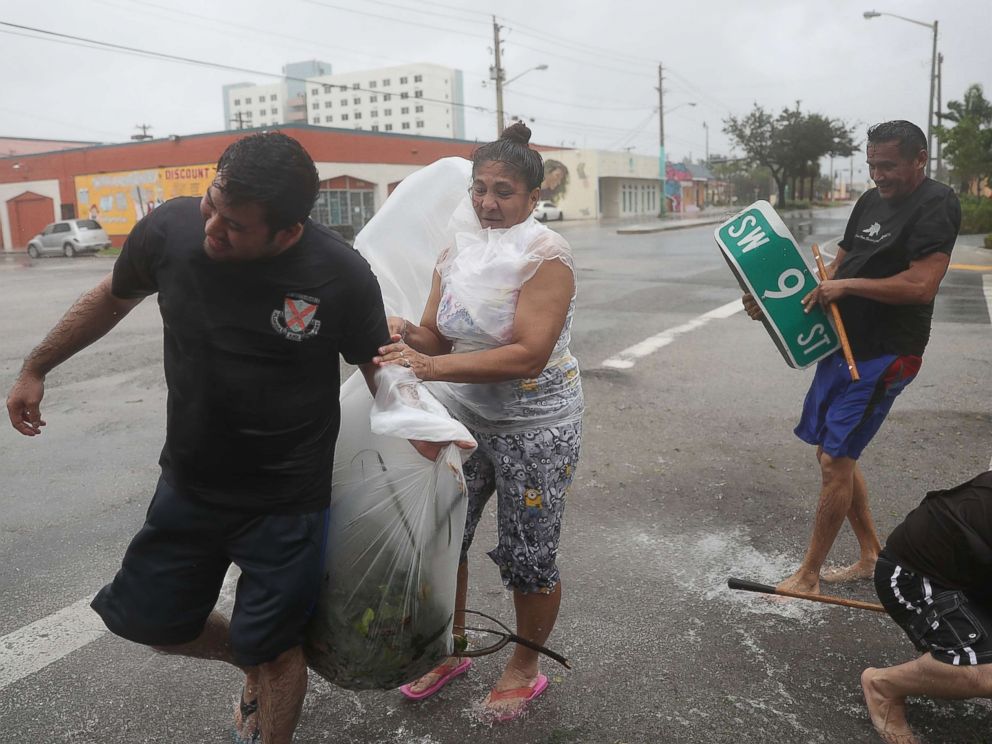 PHOTO: People clear debris out of a drainage ditch in an attempt to keep the area from flooding as Hurricane Irma passes through on Sept. 10, 2017 in Miami.