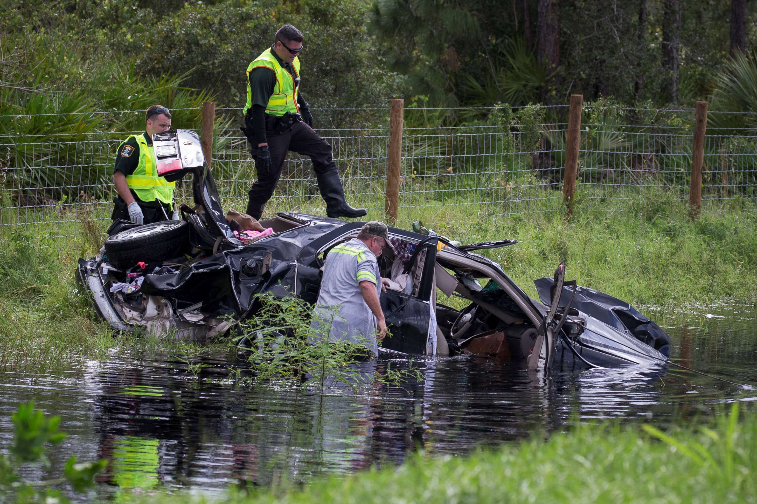 PHOTO: Police officers climb atop a vehicle while trying to salvage it from the aftermath of Hurricane Irma in North Port, Fla., Sept. 11, 2017.