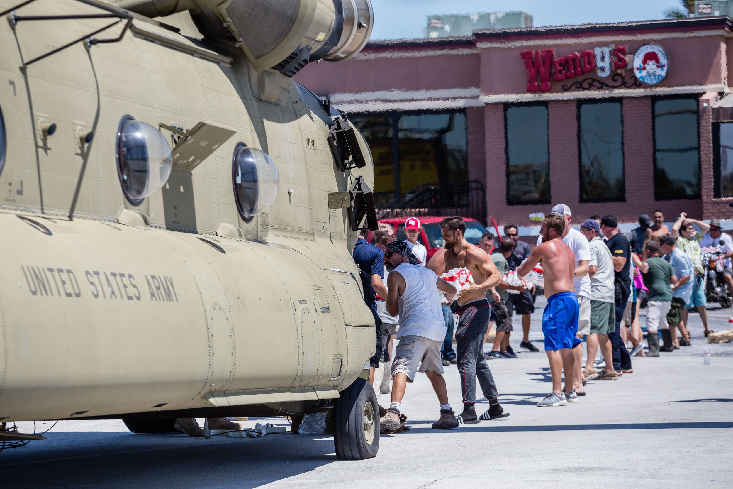 PHOTO: Local residents assist soldiers with the offloading of relief supplies from a Florida National Guard helicopter in Key West, Fla., Sept. 13, 2017.