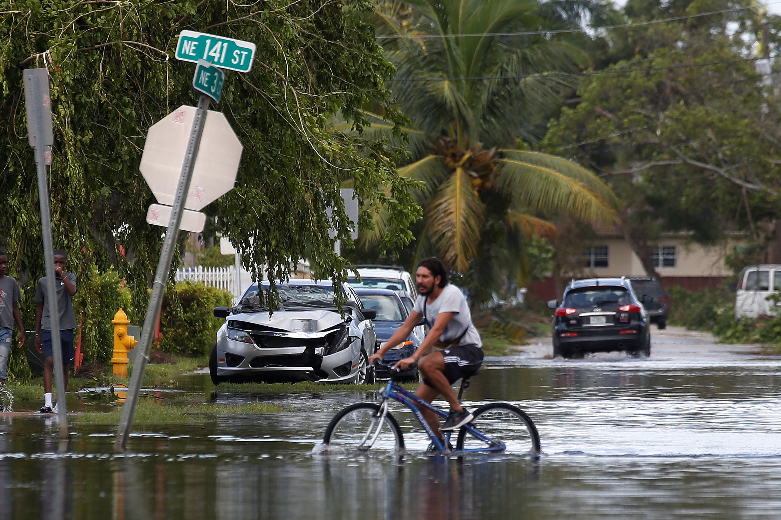 PHOTO: A man rides a bike on a flooded street following Hurricane Irma in North Miami, Sept. 11, 2017.