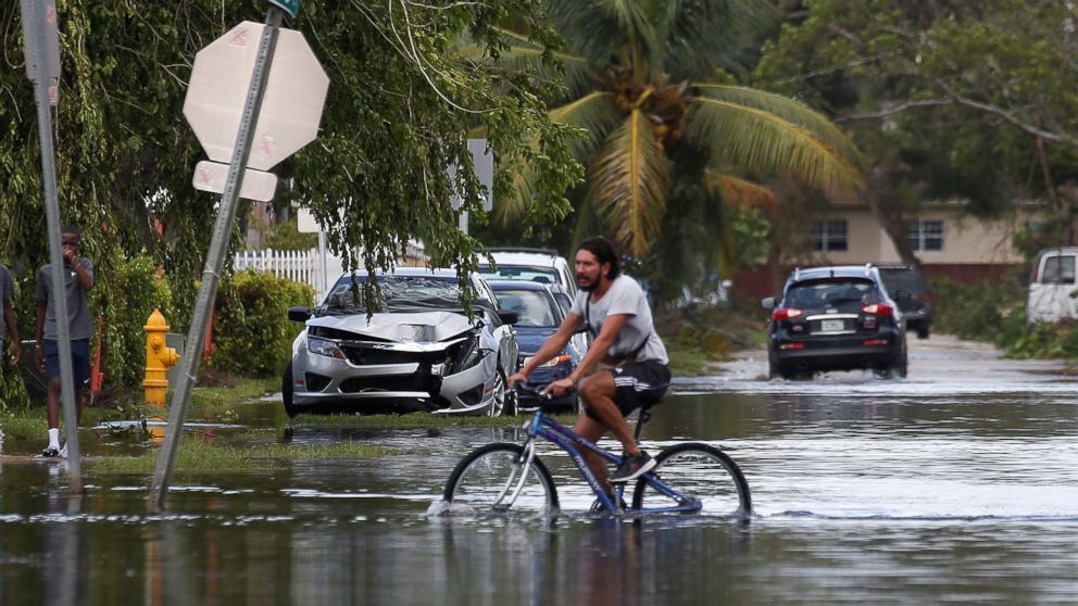PHOTO: A man rides a bike on a flooded street following Hurricane Irma in North Miami, Sept. 11, 2017.