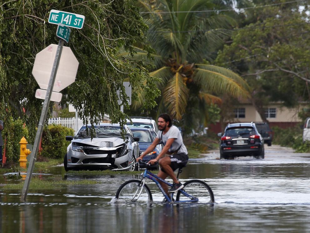 PHOTO: A man rides a bike on a flooded street following Hurricane Irma in North Miami, Sept. 11, 2017.