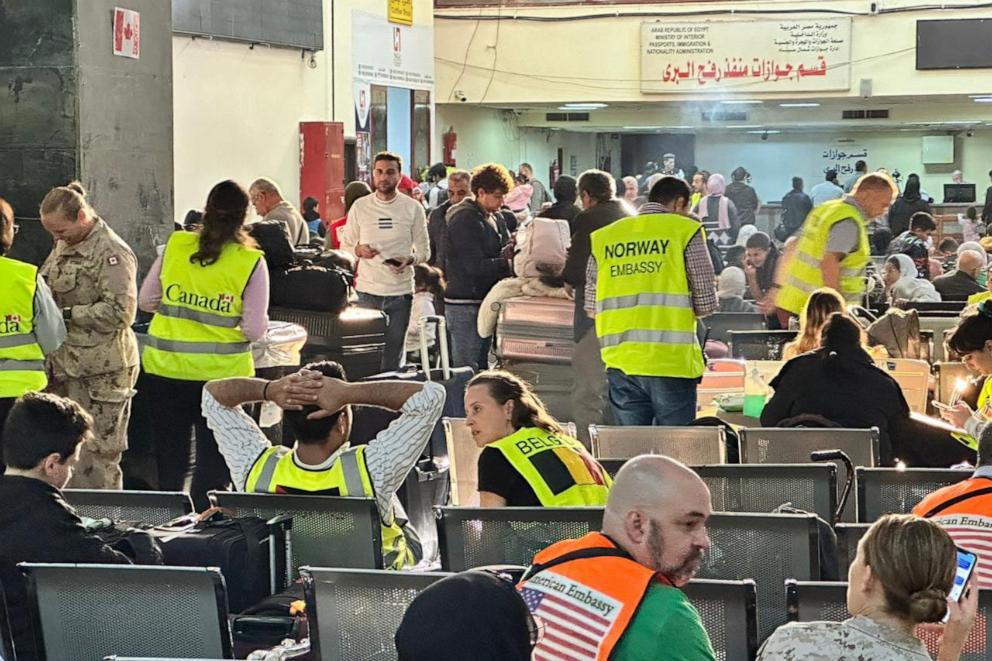 PHOTO: Representatives from different embassies stand among people fleeing from the Gaza Strip as they arrive in the Egyptian part of the Rafah border crossing with the Palestinian enclave, on Dec. 3, 2023.