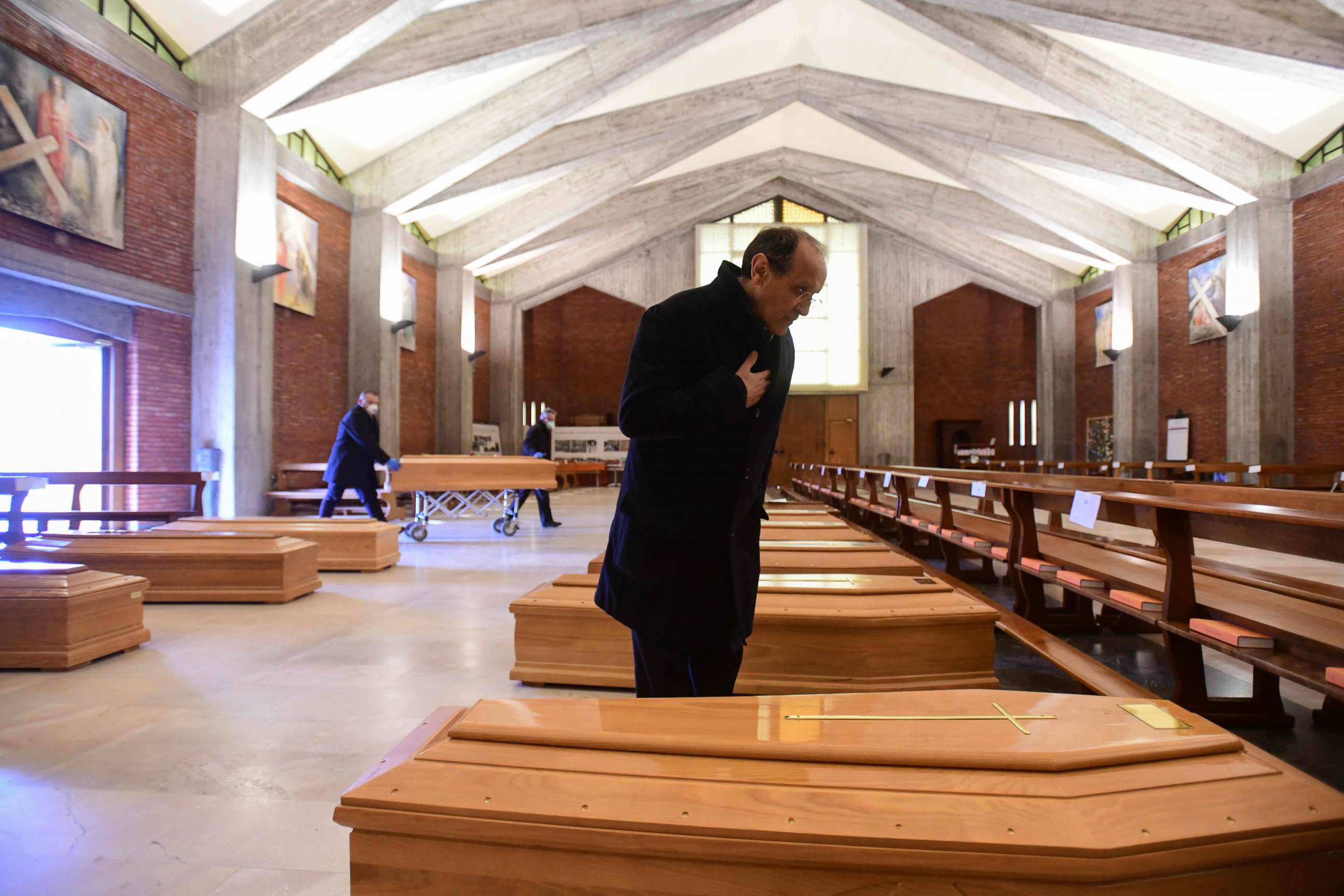 PHOTO: Parish priest of Seriate, Don Mario stands by one of the coffins stored into the church of San Giuseppe in Seriate, near Bergamo, Lombardy, on March 26, 2020, during the country's lockdown following the coronavirus pandemic.